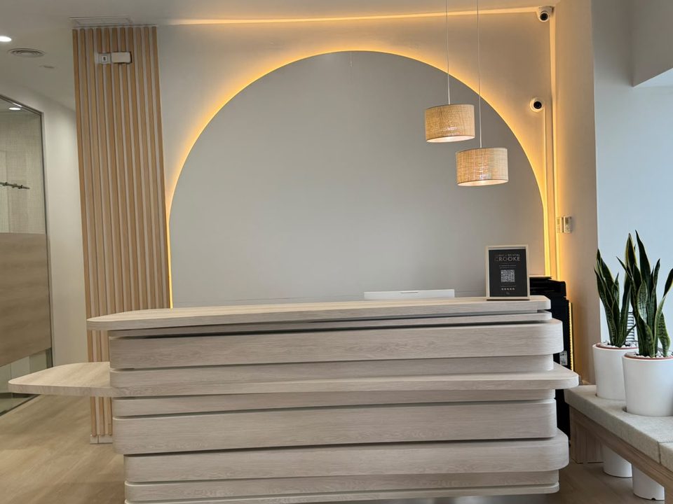 Mostrador de recepción de la clínica de Algeciras bajo el arco retroiluminado